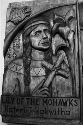 St. Kateri Tekakwitha July 14 Woodcarving, gift of the Southtowns Woodcarvers of WNY, on right (west) transept wall