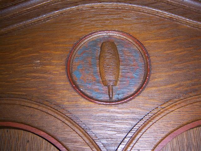 This week we celebrate Labor Day, and so we feature the woodcarvings in the rear of the church which honor the trades. This shoemaker’s awl is one of six symbols carved on the doors of the large wooden cabinet designed as the ushers’ office. All of the building’s original woodcarvings were done by two brothers from Bowmansville, NY, Richard and Albert Lippich. (Rev. Walter Kern’s Guidebook to Blessed Trinity R. C. Church, pages 23 & 24. Photo credit: Margaret Dick). 
