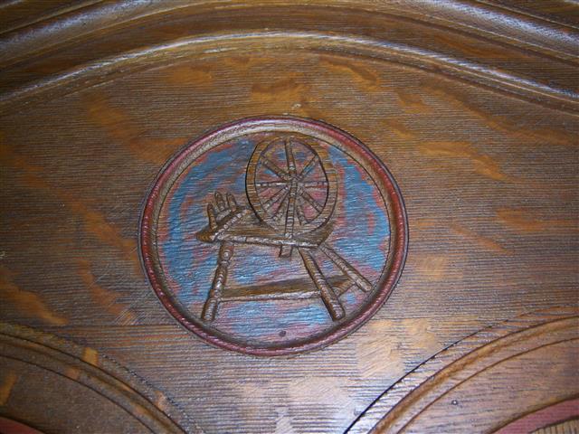 The weaver or textile worker is represented by the spinning wheel.