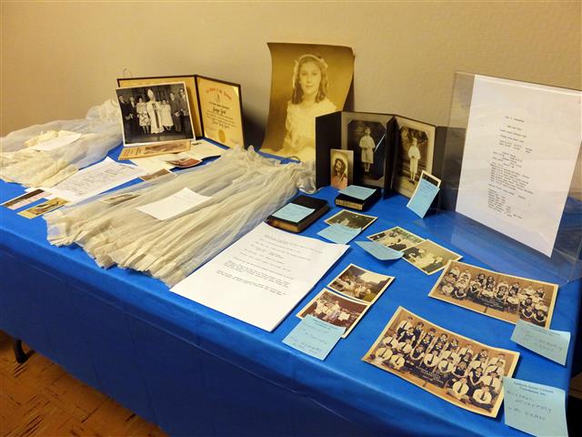 Marilyn Gesl Arcara, '45, prepared a display showing the history of 5 generations of the Gesl Family at Blessed Trinity. The display included her First Communion photo and the dress she wore.